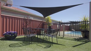 A patio with a pool, surrounded by a fence and a large shade sail. - Horsham Country City Motor Inn (Horsham)
