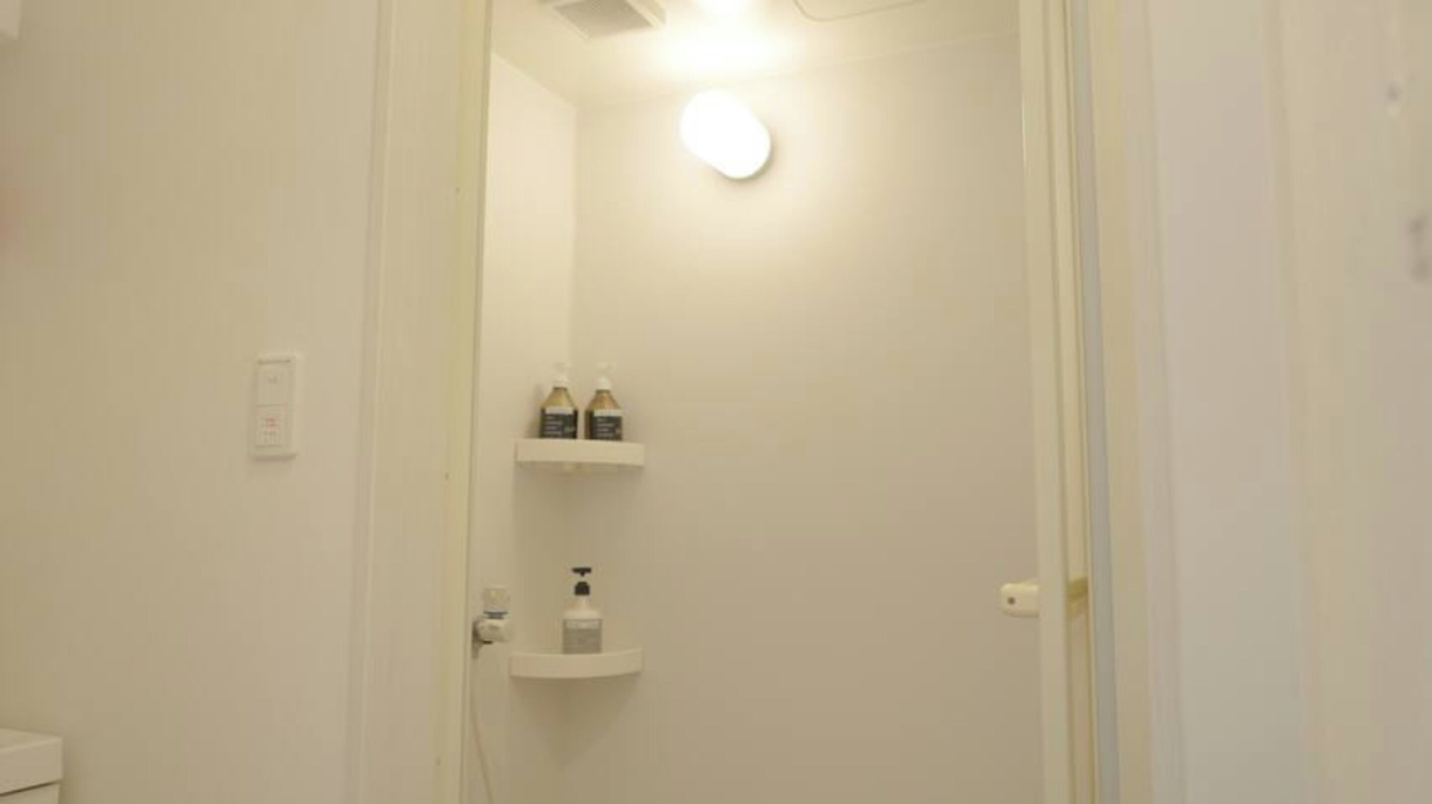 A bathroom with a toilet, a sink, and two shelves with toiletries.