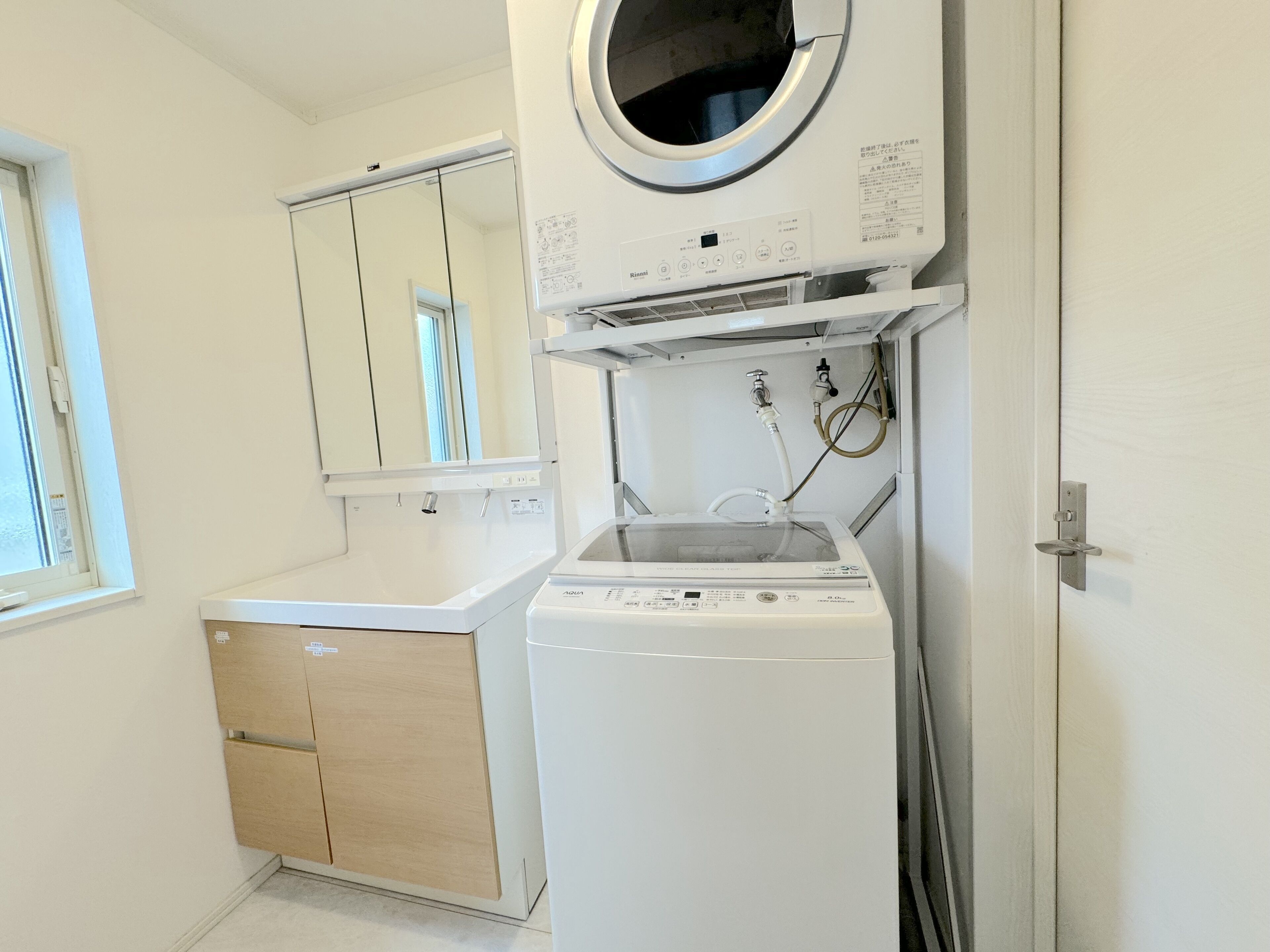 A laundry room with a washing machine, a dryer, and a mirror.