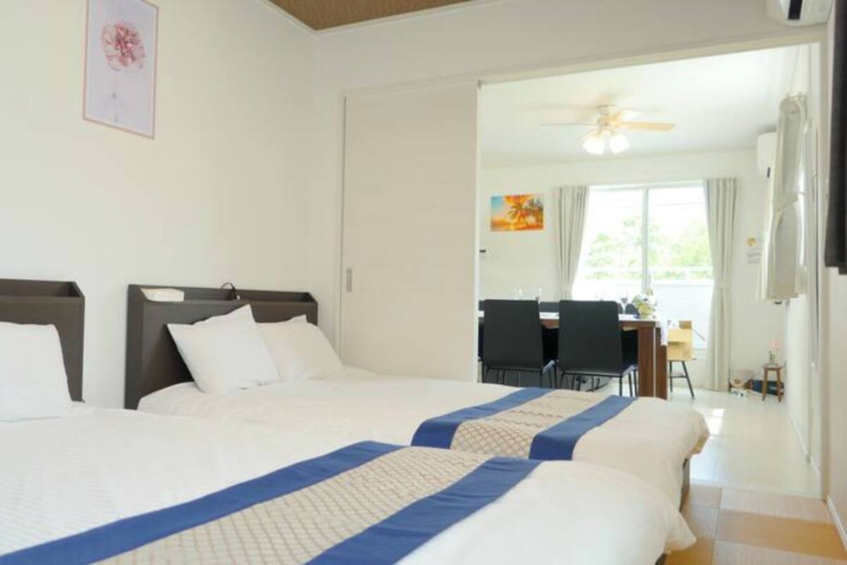 Une chambre d’hôtel avec deux lits, un ventilateur de plafond et une vue sur la salle à manger.