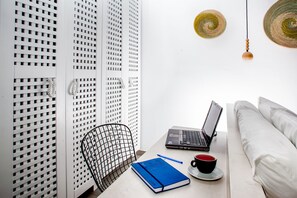 Ein modernes Zimmer mit einem Laptop auf dem Tisch, einem Notizbuch, einer Tasse und einem Stuhl.