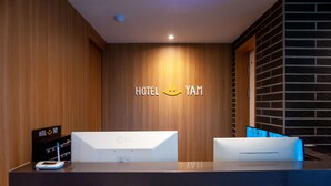 A reception desk with a wooden wall and a digital display. - Hotel  Yam YeonSan (Busan)