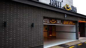 A hotel entrance with a modern brick facade and a large sign displaying the hotel name. - Hotel  Yam YeonSan (Busan)