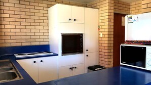 Une cuisine équipée d’un four à micro-ondes, d’une cuisinière et d’un évier.
