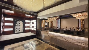 A lobby with a reception desk, seating area, and decorative lighting. - Hotel Sepal (Bathinda)