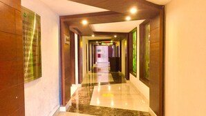 A hotel corridor with a polished marble floor, wooden paneling, and a sign listing amenities like a swimming pool and health resort. - Hotel Sepal (Bathinda)