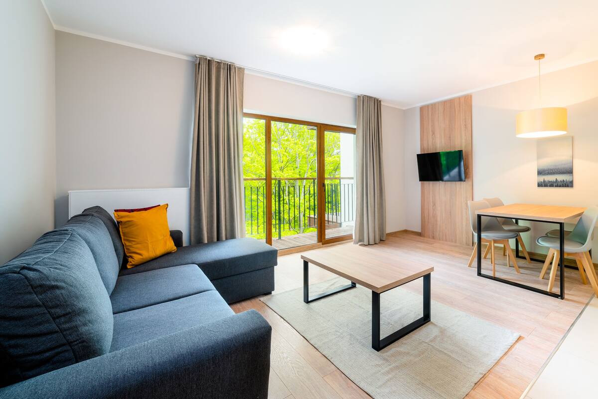 Una sala de estar moderna con un sofá, una mesa de comedor y una televisión.