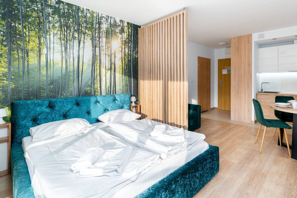 Un dormitorio moderno con una cama grande, un comedor y una cocina.