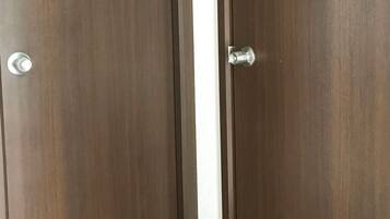 A closed wooden door with a silver handle and a small rectangular window at the top.