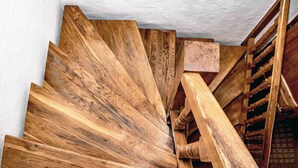 A spiral staircase with wooden steps and a wooden handrail. - Feriendorf Büchelberg (Windorf)