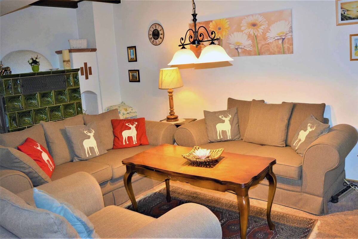 A cozy living room with a sectional sofa, a wooden coffee table, and a lamp.