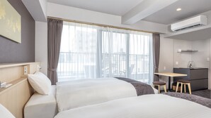 A hotel room with two beds, a desk, and a kitchenette. - hotel GOCO stay Kyoto Shijo Kawaramachi (Kyoto)