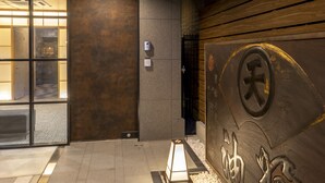 A hotel entrance with a tiled floor, a wall-mounted sign with Chinese characters, and a small illuminated lantern. - hotel GOCO stay Kyoto Shijo Kawaramachi (Kyoto)