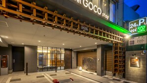 A hotel entrance with a 24-hour parking sign, a reception desk, and a modern facade. - hotel GOCO stay Kyoto Shijo Kawaramachi (Kyoto)