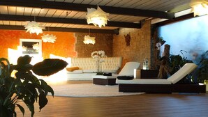 A modern living room with a white sofa, two lounge chairs, and hanging paper lanterns. - Ferienhaus Sine Tempo (Marktleugast)