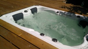 A hot tub on a wooden deck. - Ferienhaus Sine Tempo (Marktleugast)