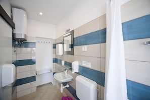 A bathroom with a toilet, sink, and hand dryer. - Apartments Bulovic (Split)