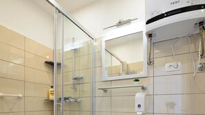 A modern bathroom with a glass shower enclosure, a white sink, and a toilet. - Apartments Bulovic (Split)