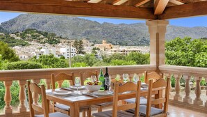 Mesa de madera preparada para comer con vista a un pueblo montañoso.