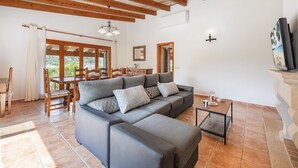 Una sala moderna con un sofá modular, una mesa de comedor de madera y sillas.