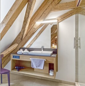 A bathroom with a wooden ceiling, a sink, a mirror, and a towel rack. - Zum Alten Fritz (Weigendorf)
