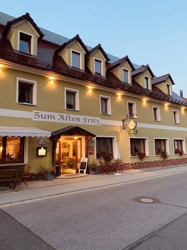 A building with a sign reading "Zum Alten Fritz" and a clock above the entrance. - Zum Alten Fritz (Weigendorf)