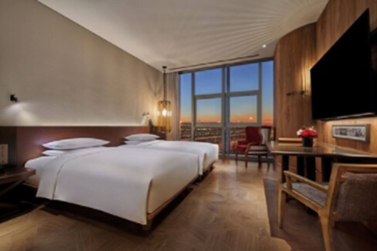 Ein Hotelzimmer mit einem großen Bett, einem Schreibtisch und einem Fernseher.