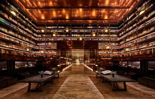 Uma biblioteca com vários andares de estantes e um corredor central.