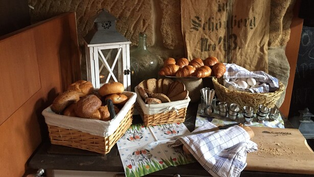 Una cocina rústica con cestas de pan, un farol y una tabla de cortar.