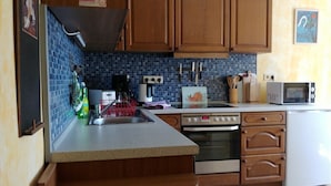 Una cocina con armarios de madera, un lavamanos, un microondas y un tostador.