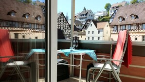 Un balcon avec une table, des chaises et une vue sur des bâtiments européens traditionnels.