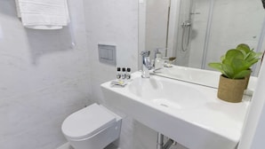 Ein modernes Badezimmer mit Waschbecken, Toilette, Dusche und Spiegel.