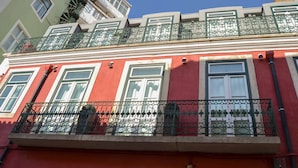 Ein rotes Gebäude mit Balkonen, Fenstern und einem sichtbaren Brandschutztreppenhaus.