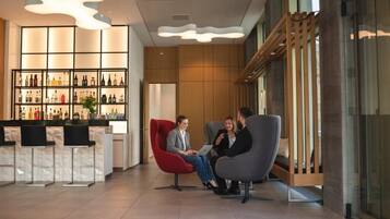 En modern entréhall med en bardisk, sittplatser och ett stort utbud av spritflaskor i utställningen.