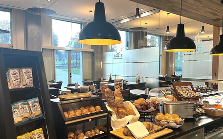 A bakery display with various baked goods and a coffee station.