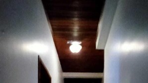 A narrow hallway with a wooden ceiling and a tiled floor. - Kural Pansiyon (Ayvalik)