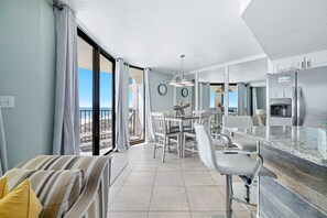 Una cocina moderna con refrigerador incorporado, un comedor con mesa y sillas, y un balcón con vistas.