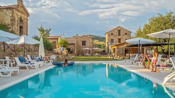 Una piscina al aire libre de temporada, sombrillas