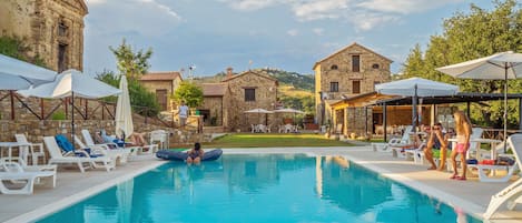 Una piscina al aire libre de temporada, sombrillas