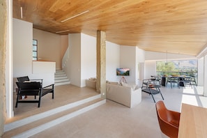A spacious living area with a staircase, a dining area with outdoor view, and a painting on the wall. - Exclusive Casa Mir located in 'el Vila' with Pool & with all amenities (Puerto Pollensa)