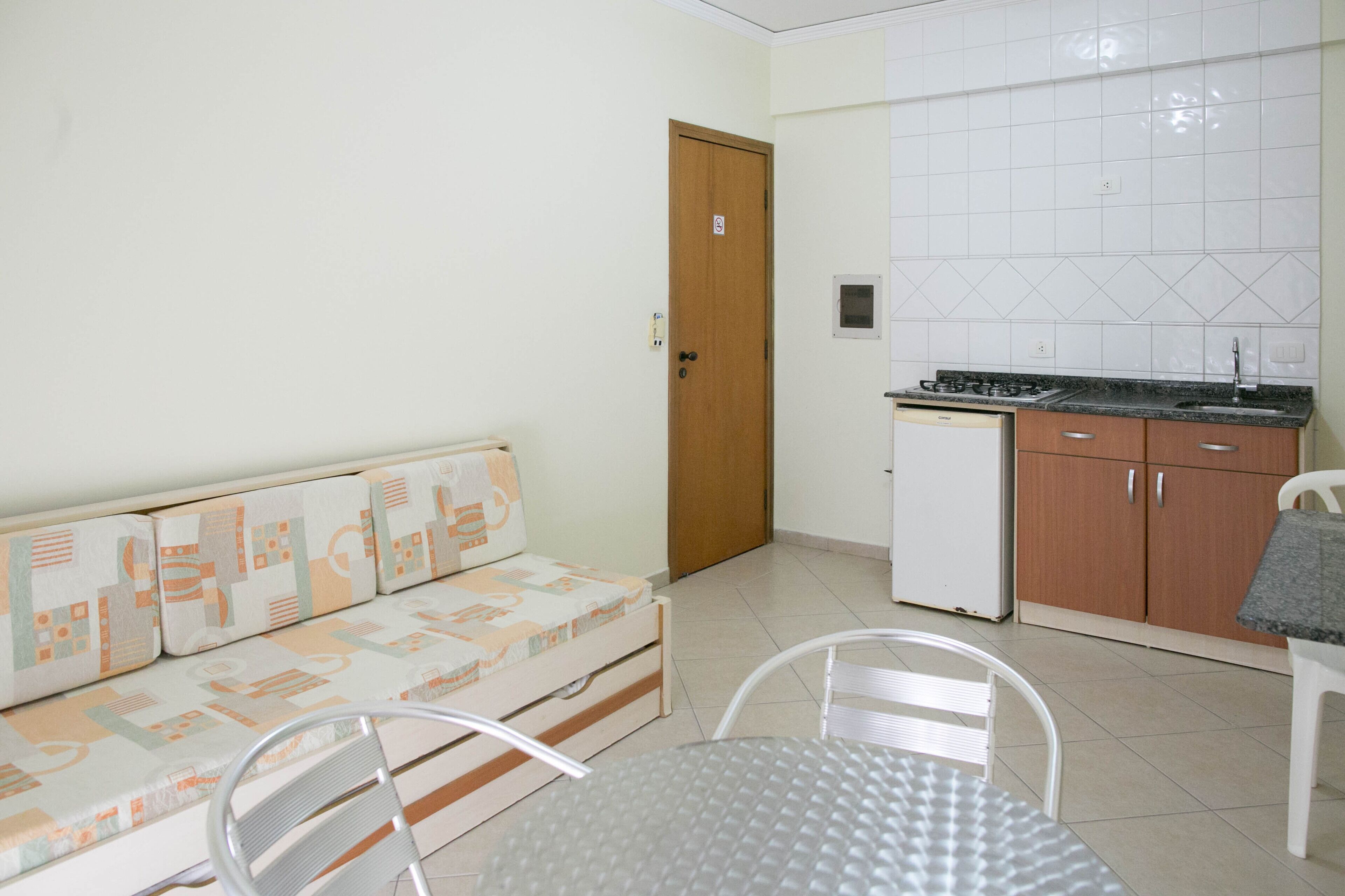 A compact living space with a sofa, a small dining table, and a kitchenette.