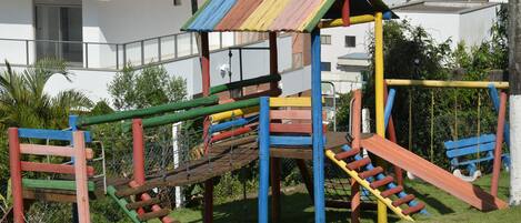 Un parque infantil con una estructura de escalada multicolores y toboganes.