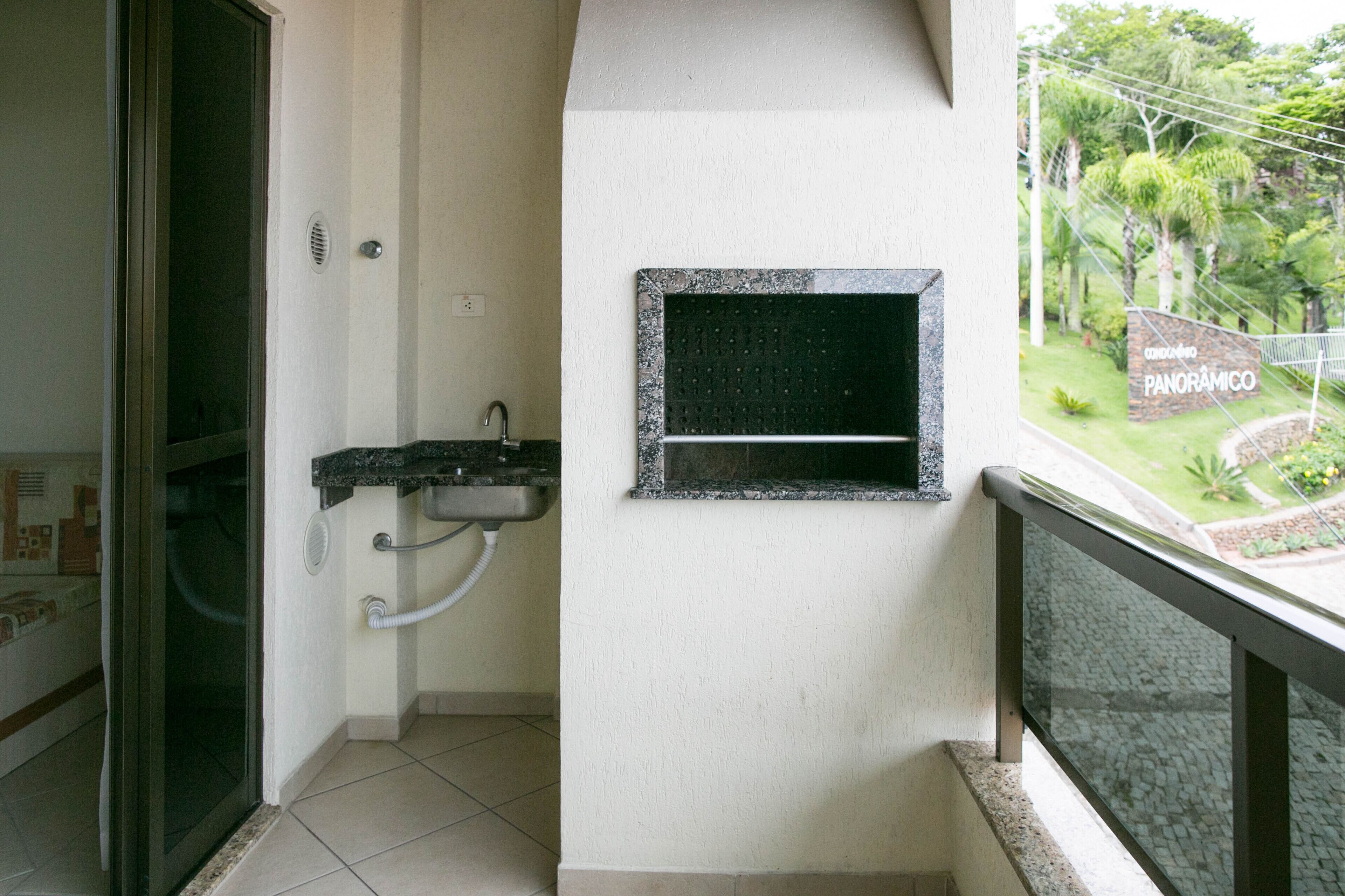 Un baño con lavamanos, ventana y vista a un jardín.