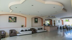 A spacious lobby with a reception desk, seating area, and a modern ceiling design. - Hotel RRU Diamante (Acapulco)