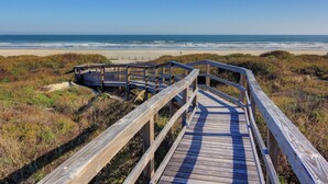 A wooden boardwalk leading to a beach with a clear view of the ocean. - Beach Access! Heated Community Pool! Float in the pool while looking at the beac (Port Aransas)
