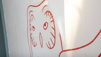 A whiteboard with a red outline drawing of a cat's face.
