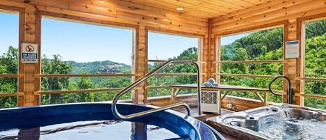 Una cabaña de madera con jacuzzi y sauna, grandes ventanales con vistas al bosque.