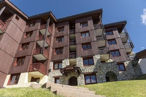 En byggnad med flera våningar, balkonger, dekorativa stenelement och en skylt som visar att det är ett hotell.