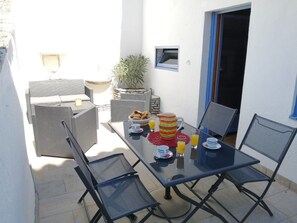 Enjoy dining al fresco in this patio area with a glass table and comfortable seating for two.