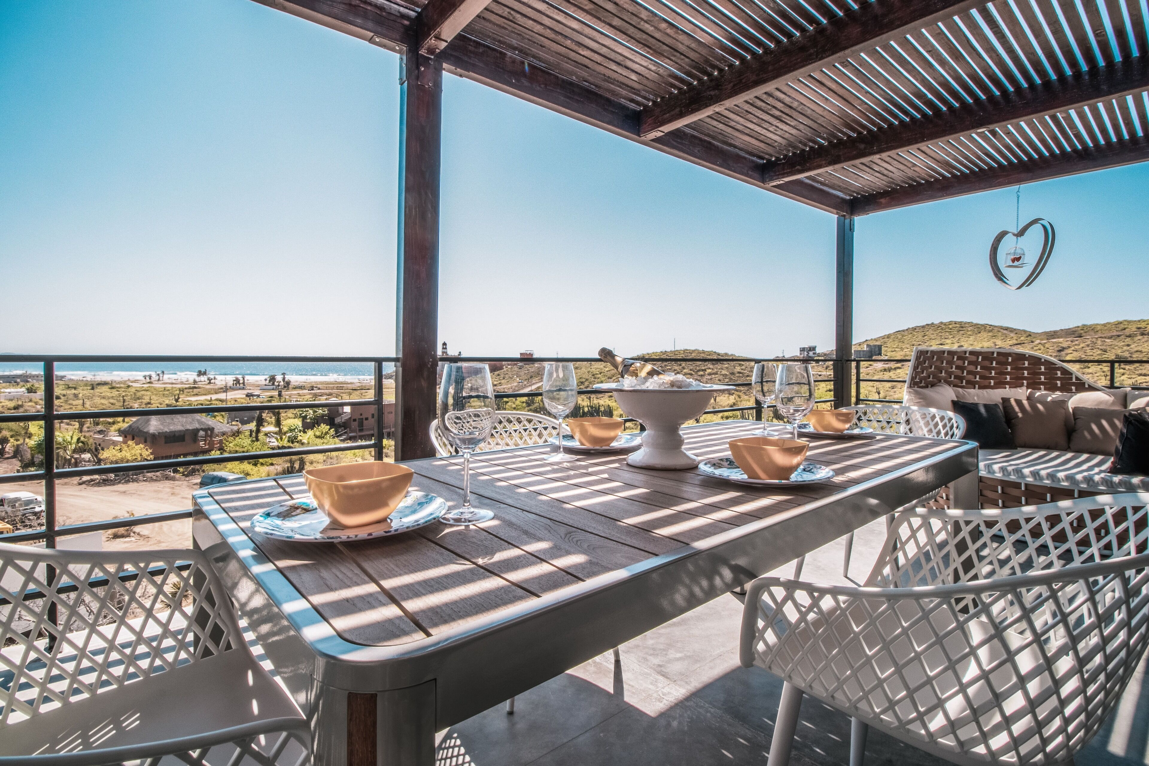 Un patio al aire libre con una mesa lista para comer, con vistas a un paisaje pintoresco.